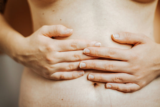 Frau legt Hände auf den Bauch