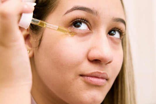 Frau trägt ein natürliches Gesichtsöl zur Pflege unreiner Haut auf